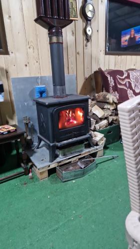 a stove in a living room with a green floor at Casa bunicilor din Leresti in Voineşti
