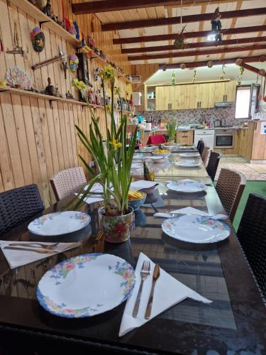a long table with plates and utensils on it at Casa bunicilor din Leresti in Voineşti
