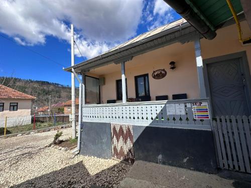 a house with a white fence and a gate at Casa bunicilor din Leresti in Voineşti