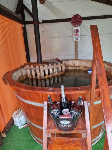 a barrel with two bottles of beer in it at Casa bunicilor din Leresti in Voineşti