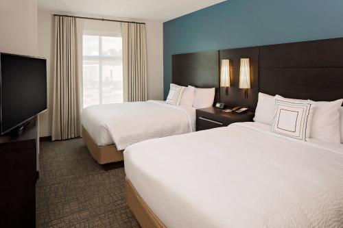 a hotel room with two beds and a flat screen tv at Residence Inn by Marriott Charleston Summerville in Summerville