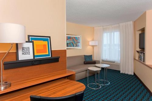 a hotel room with a couch and a table at Fairfield Inn and Suites by Marriott Chicago St. Charles in Saint Charles