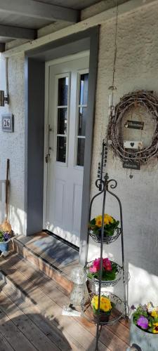 a front door of a house with flowers on a porch at Cosy Home in Scharbeutz