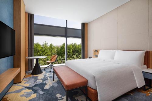 sypialnia z łóżkiem i dużym oknem w obiekcie Four Points by Sheraton Shanghai Jiading w Szanghaju