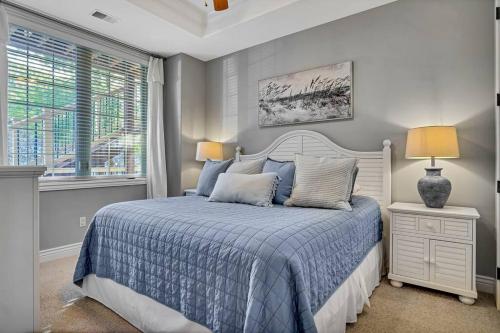 a bedroom with a bed with a blue comforter and a window at WALK IN Two bed Lakeview at Indian Point in Branson