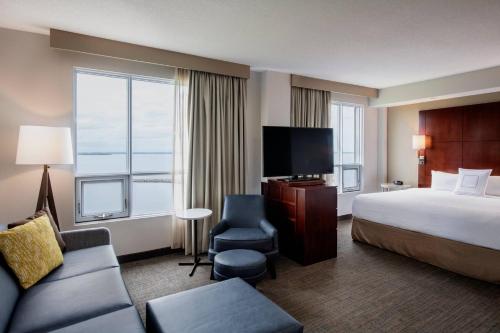 a hotel room with a bed and a large window at Residence Inn by Marriott Kingston Water's Edge in Kingston