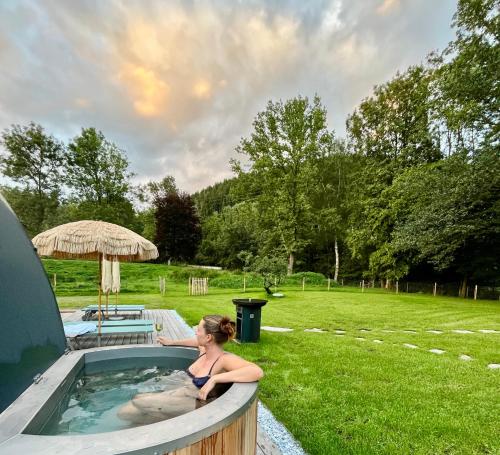 a woman sitting in a hot tub in a yard at Chalet 1888 in Bad Sankt Leonhard im Lavanttal