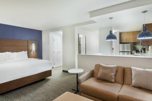 um quarto de hotel com uma cama e um sofá em Residence Inn by Marriott Buffalo Downtown em Buffalo