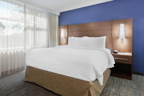 a large bed in a hotel room with a large window at Residence Inn by Marriott Buffalo Downtown in Buffalo