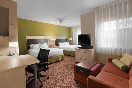 a hotel room with two beds and a tv at TownePlace Suites by Marriott Lake Jackson Clute in Clute