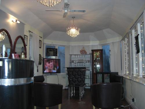 a bar with black chairs and a chandelier at Lynebank House Hotel, Bed & Breakfast in Carlisle