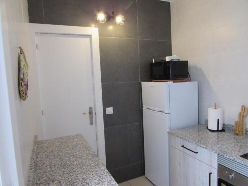 a small kitchen with a refrigerator and a counter at MOJACAR HOME AND BEACH in Mojácar