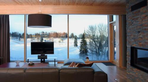uma sala de estar com uma grande janela e uma televisão em Otepää Holiday Home em Otepää