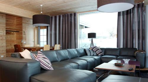 - un salon avec un canapé en cuir bleu dans l'établissement Otepää Holiday Home, à Otepää