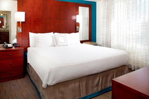 a bedroom with a large bed with a wooden headboard at Residence Inn Tampa Suncoast Parkway at NorthPointe Village in Lutz