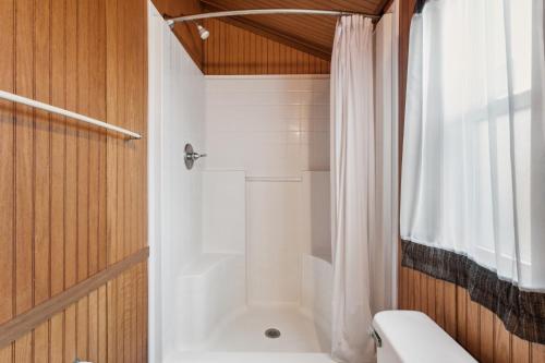 a bathroom with a shower and a white toilet at Camp Cardinal in Broad Marsh