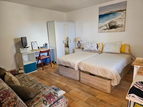 Playa del HombreにあるEstudio Brisa Canariaのベッドルーム1室(ベッド2台、デスク、ソファ付)