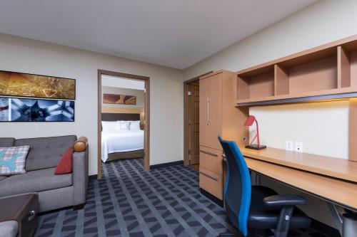 Camera con scrivania, divano e letto. di TownePlace Suites by Marriott East Lansing a East Lansing
