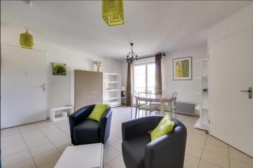 un salon avec deux chaises et une table dans l'établissement Agréable Appartement 3* non loin de l’Océan, à Biscarrosse