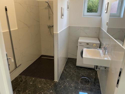 a bathroom with a sink and a washing machine at Monteurunterkunft Langenhorst in Groß Niendorf