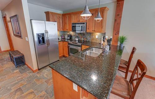 a kitchen with a refrigerator and a counter top at Large Studio Condo with Full Kitchen, Ski, Bike, Beautiful Balcony Views Hottub Fireplace in Kellogg