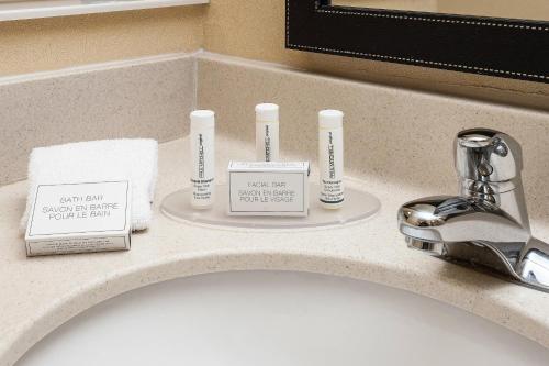 a bathroom sink with three bottles on a counter at Fairfield Inn & Suites by Marriott Anchorage Midtown in Anchorage