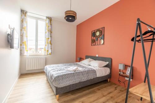 - une chambre dotée d'un lit avec un mur orange dans l'établissement F3 Grand Luxe Champfleuri (B), à Clermont-Ferrand