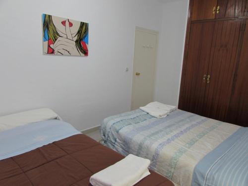 a bedroom with two beds and a painting on the wall at MOJACAR HOME AND BEACH in Mojácar