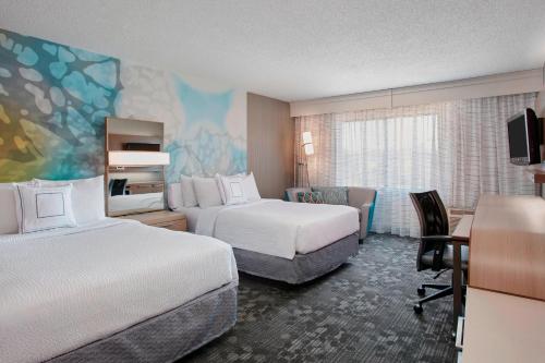 a hotel room with two beds and a desk at Courtyard by Marriott Detroit Pontiac/Auburn Hills in Pontiac