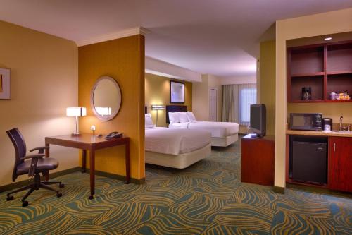 Habitación de hotel con cama, escritorio y TV. en SpringHill Suites by Marriott Cedar City, en Cedar City