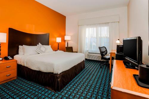 a hotel room with a bed and a flat screen tv at Fairfield by Marriott Wilkes-Barre in Wilkes-Barre