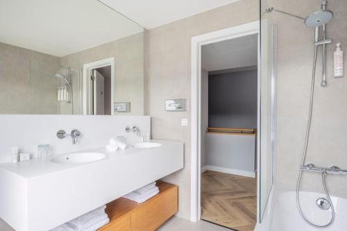a bathroom with two sinks and a shower at Marriott Executive Apartments Brussels in Brussels