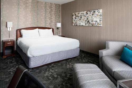 um quarto de hotel com uma cama e um sofá em Courtyard by Marriott Seattle Federal Way em Federal Way