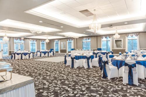 un salón de banquetes con mesas y sillas azules y blancas en The Inn On Sheridan, en Zion