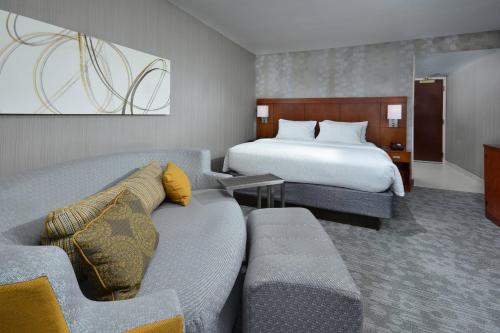 a hotel room with a couch and a bed at Courtyard Beckley in Beckley