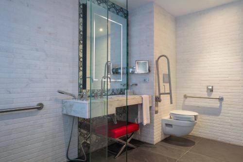 a bathroom with a glass shower with a toilet at Le Meridien Oran Hotel in Oran