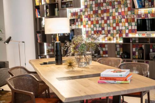 una mesa de madera con sillas y una lámpara y libros. en Renaissance Brussels Hotel, en Bruselas