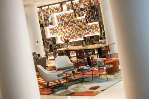 Habitación con mesa, sillas y una pared de botellas. en Renaissance Brussels Hotel, en Bruselas