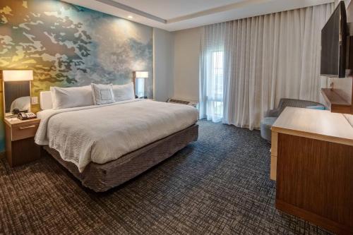 a hotel room with a large bed with a painting on the wall at Courtyard Austin by Marriott Northwest/Lakeline in Austin