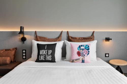 a bedroom with a bed with pillows on it at Moxy Amiens in Amiens