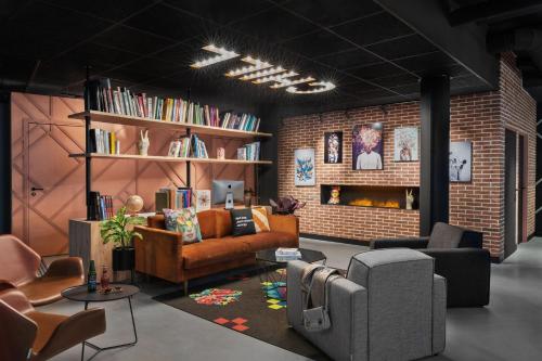 a living room filled with furniture and a brick wall at Moxy Amiens in Amiens