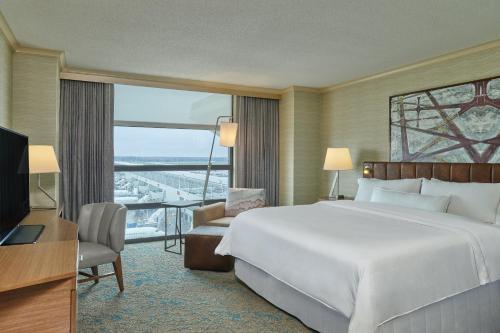 a hotel room with a large bed and a television at The Westin Detroit Metropolitan Airport in Romulus