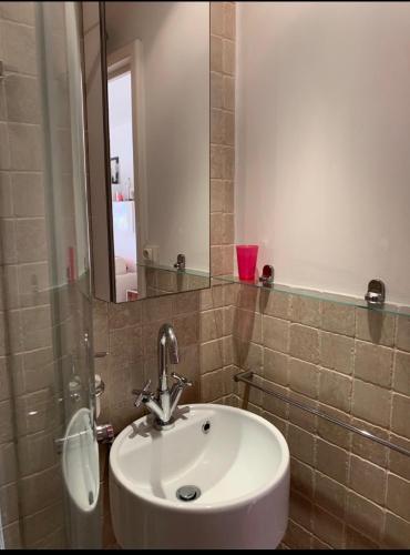 une salle de bain avec un lavabo blanc et un miroir dans l'établissement Terrasse ensoleillée sur les canaux, à Grimaud