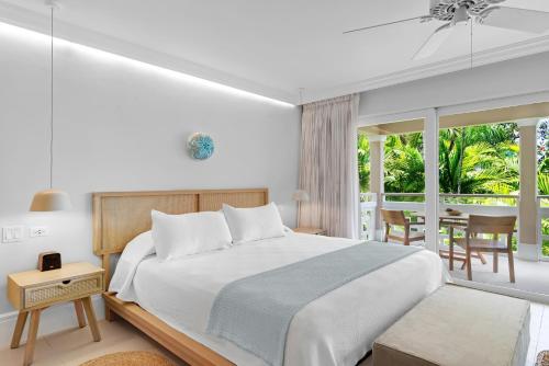 a bedroom with a large bed and a dining room at Couples Sans Souci in Ocho Rios