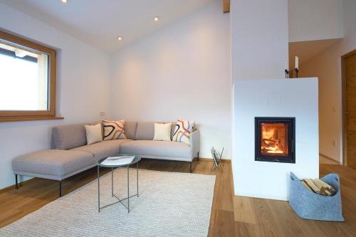 a living room with a couch and a fireplace at Ciasa Plandros Apartments in La Valle
