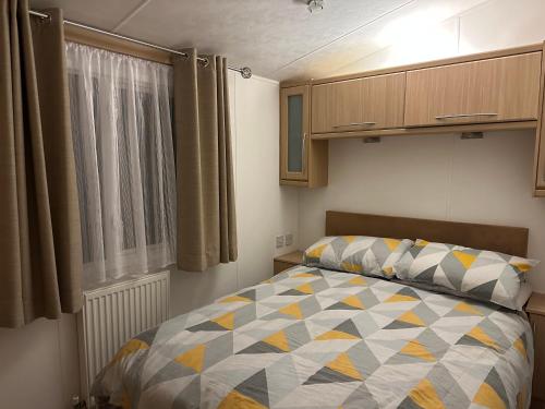 een slaapkamer met een bed en een raam bij Charming 5-Beds Caravan in beautiful Seton Sands in Port Seton