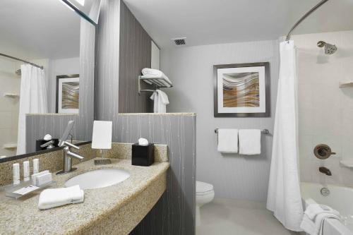 a bathroom with a sink and a toilet at Courtyard by Marriott Toronto Brampton in Brampton