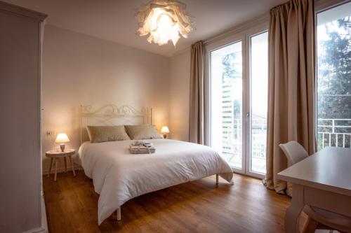 - une chambre avec un lit blanc et une grande fenêtre dans l'établissement B&B Quattro Stagioni Charme and Wellness, à Besnate