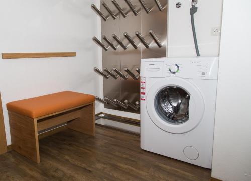 a laundry room with a washing machine and a stool at Appartement Alpenfex in Flachau
