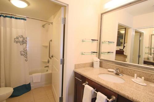 a bathroom with a sink and a shower and a mirror at Residence Inn Newport News Airport in Newport News